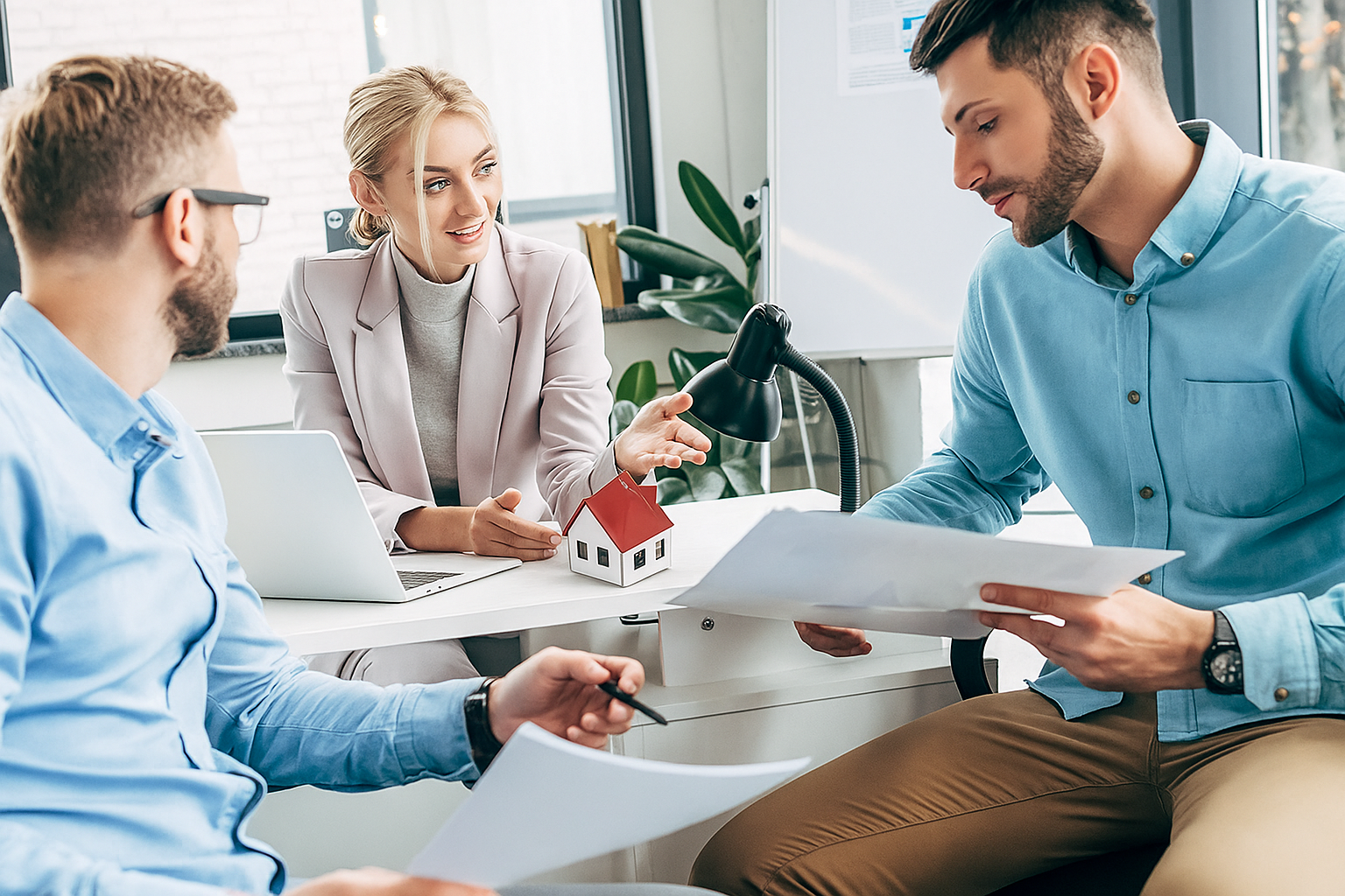 three people in an office discussing houses